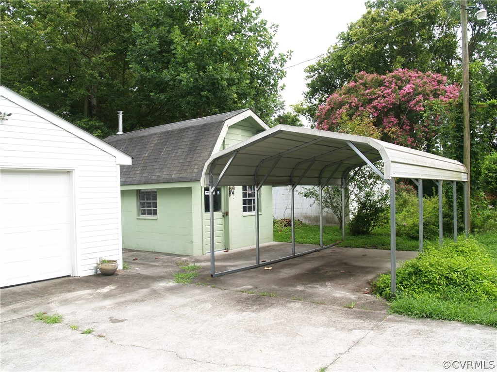 Metal carport over concrete pad.