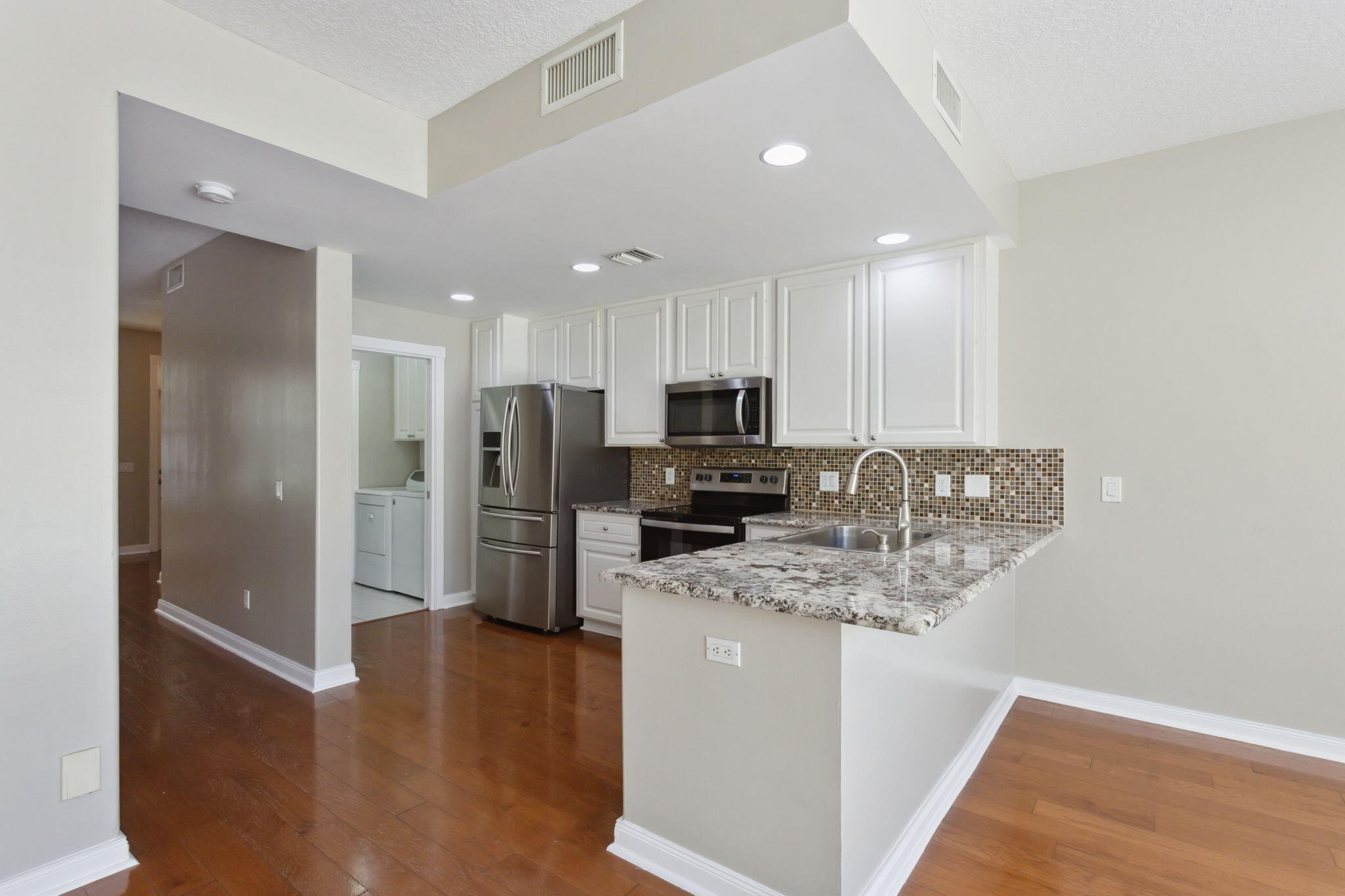 155 Waterford Drive Jupiter, FL 33458 - Photo 15 of 51 a kitchen with stainless steel appliances granite countertop a refrigerator and a stove top oven