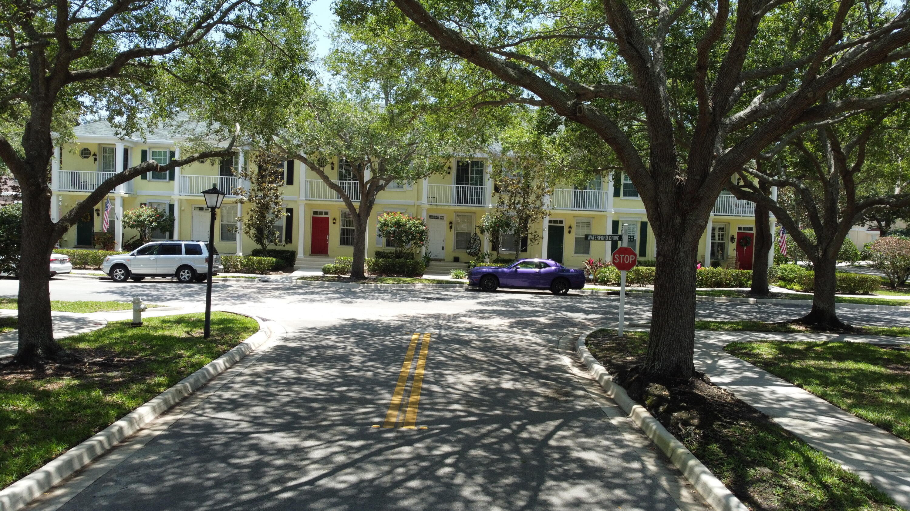 155 Waterford Drive Jupiter, FL 33458 - Photo 2 of 51 a street view with large trees