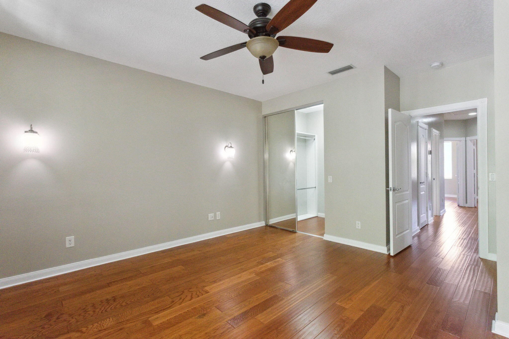 155 Waterford Drive Jupiter, FL 33458 - Photo 23 of 51 an empty room with wooden floor and a ceiling fan