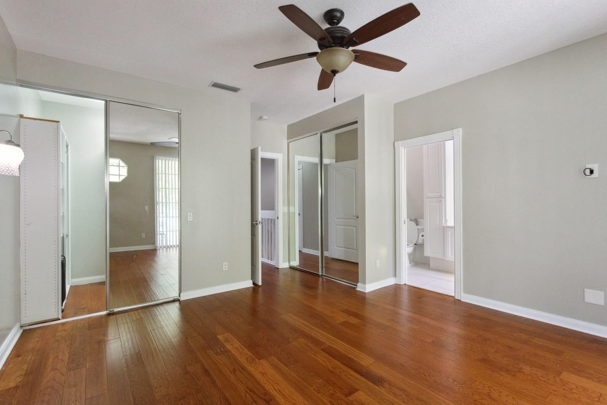 155 Waterford Drive Jupiter, FL 33458 - Photo 24 of 51 an empty room with wooden floor and a ceiling fan