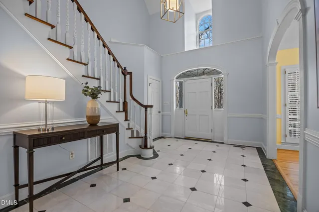 a kitchen with stainless steel appliances granite countertop a refrigerator a sink dishwasher a stove and white cabinets with wooden floor