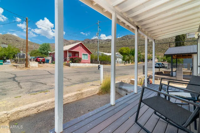 a view of a patio with table and chairs next to a yard with wooden floor