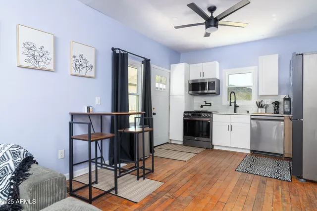 a kitchen with granite countertop a refrigerator cabinets and wooden floor