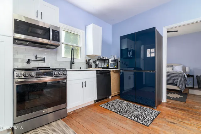a kitchen with stainless steel appliances a stove a microwave and a sink