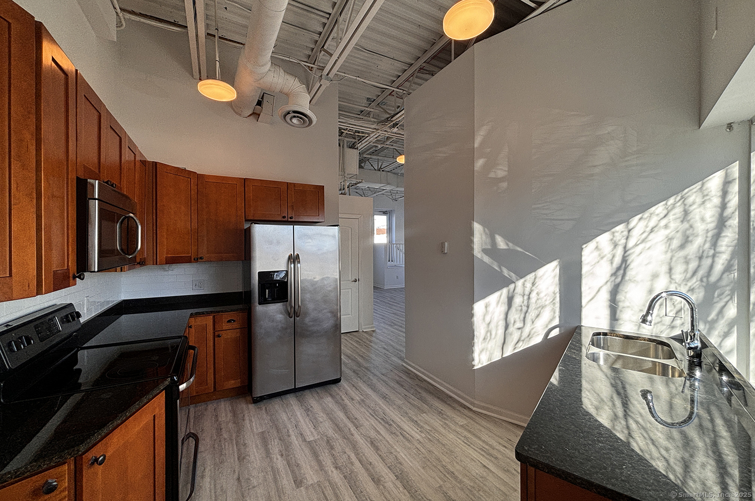 a kitchen with stainless steel appliances granite countertop a stove a sink and a refrigerator