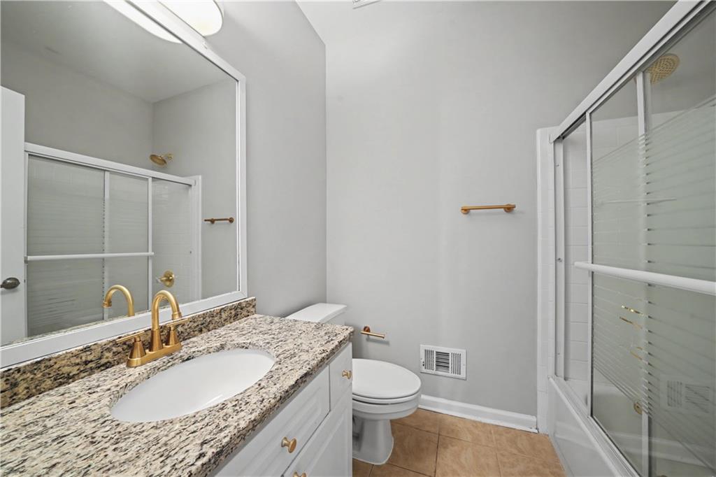 195 Brightmore Way Alpharetta, GA 30005 - Photo 12 of 30 a bathroom with a granite countertop sink toilet and shower
