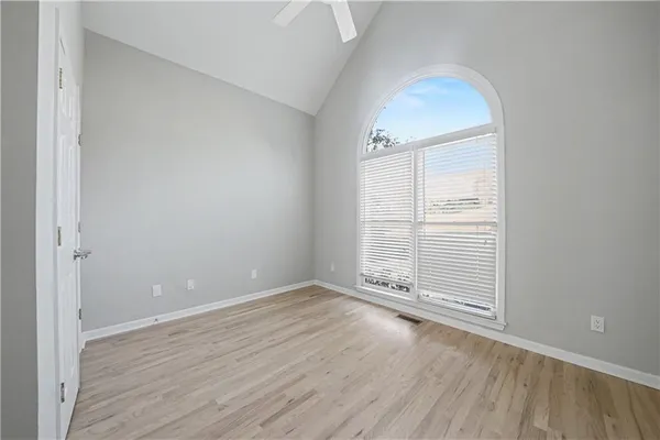 an empty room with wooden floor and windows