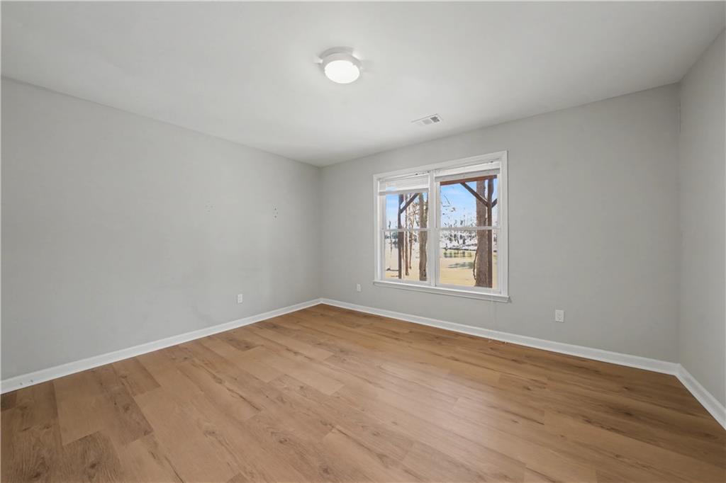 195 Brightmore Way Alpharetta, GA 30005 - Photo 16 of 30 wooden floor in an empty room with a window