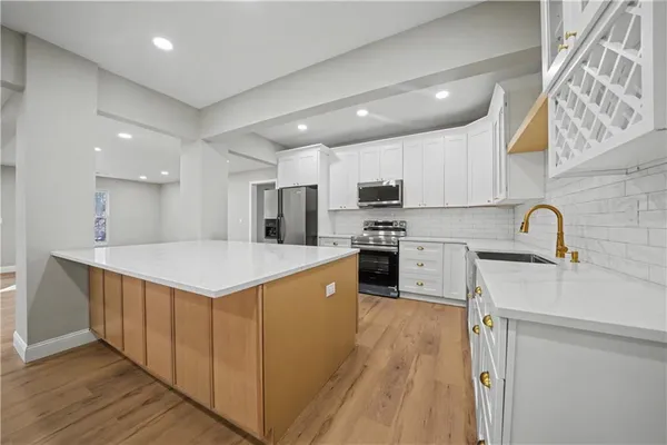 a kitchen with stainless steel appliances granite countertop a sink a stove and a refrigerator