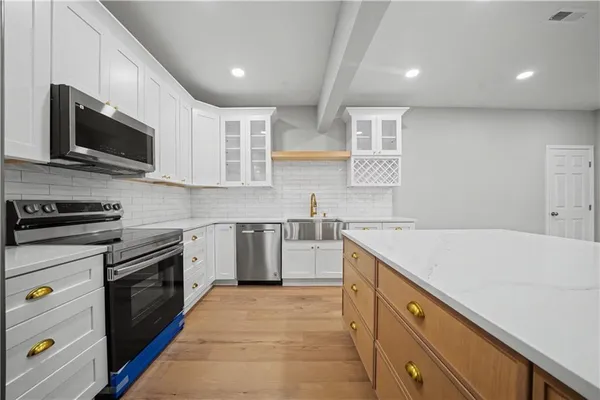 a kitchen with a sink stove and microwave