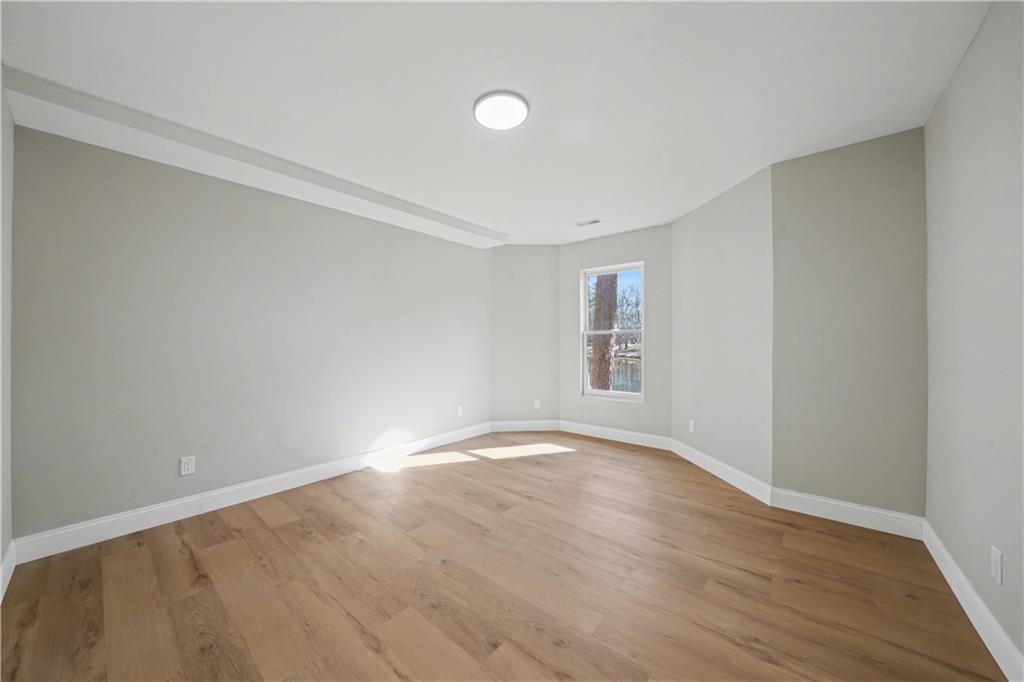 195 Brightmore Way Alpharetta, GA 30005 - Photo 22 of 30 a view of an empty room with wooden floor and a window