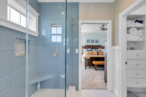 a bedroom with a bed and glass walk in closet