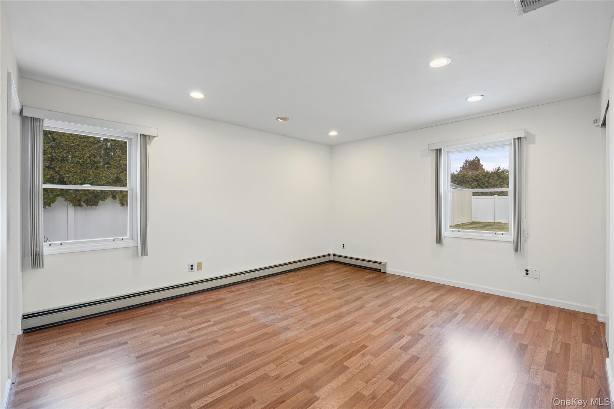 6 Hillview Court Commack, NY 11725 - Photo 19 of 43 an empty room with wooden floor and windows