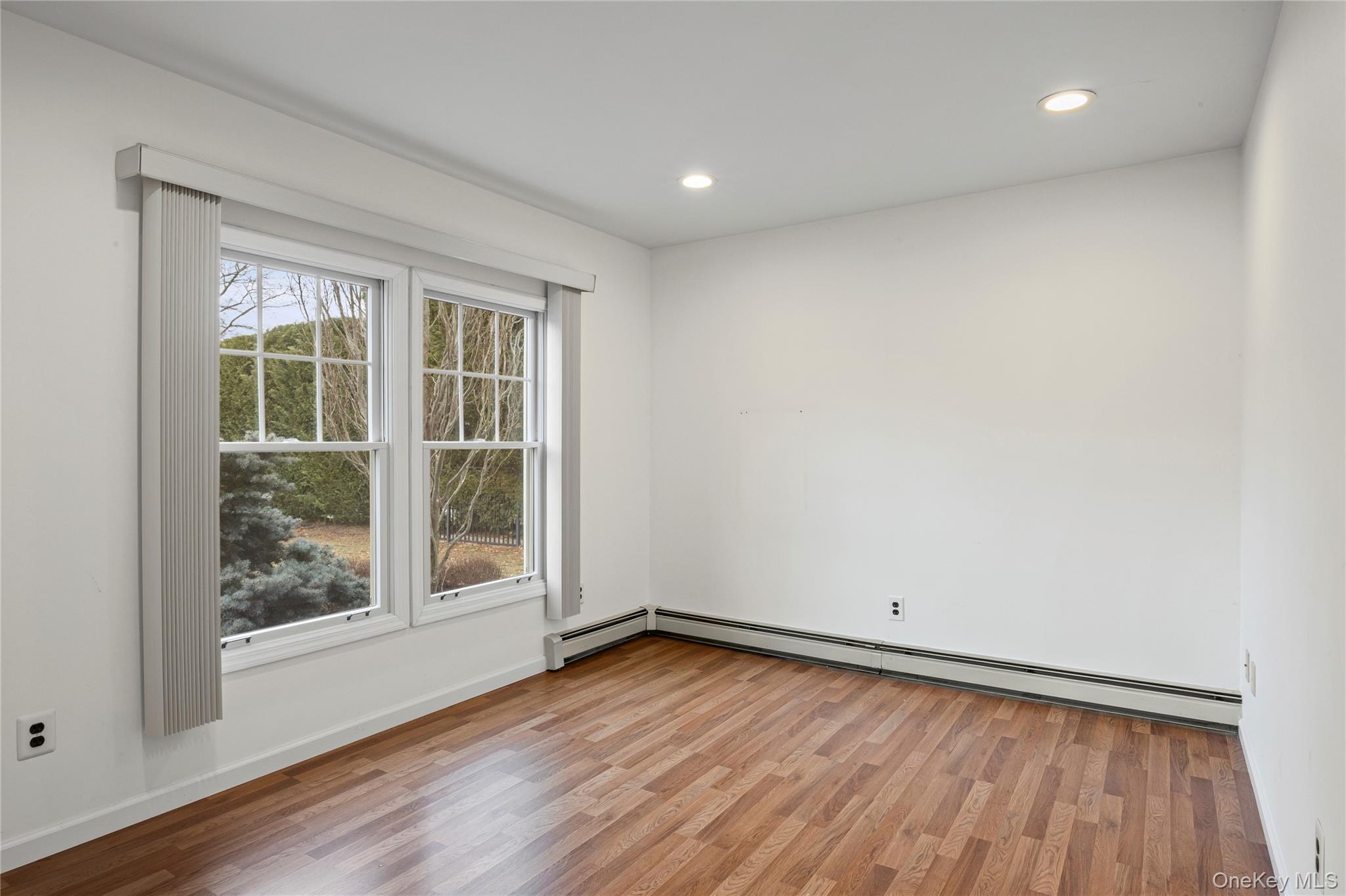 6 Hillview Court Commack, NY 11725 - Photo 22 of 43 an empty room with wooden floor and windows
