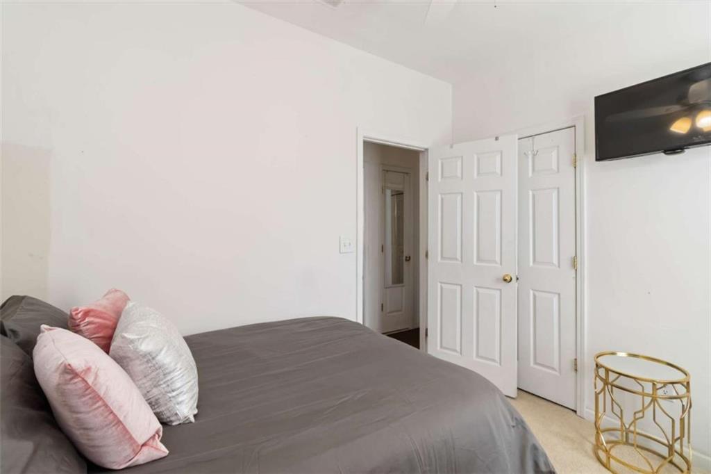 782 Jasperson Court Fairburn, GA 30213 - Photo 15 of 30 a bedroom with a bed and a flat screen tv