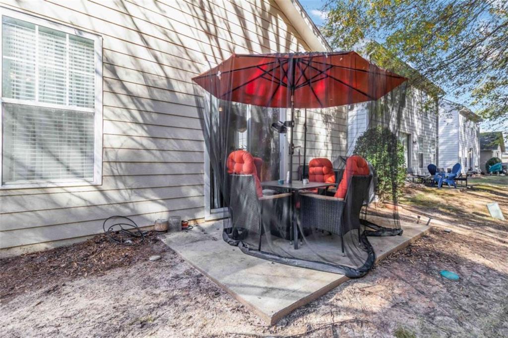 782 Jasperson Court Fairburn, GA 30213 - Photo 22 of 30 a view of a patio with a table and chairs under an umbrella