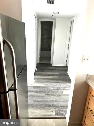 a view of a room with wooden floor fireplace and hallway