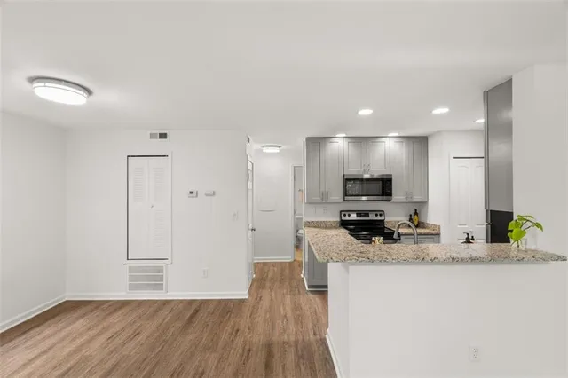 a view of a kitchen with kitchen island a counter top space a sink and stainless steel appliances