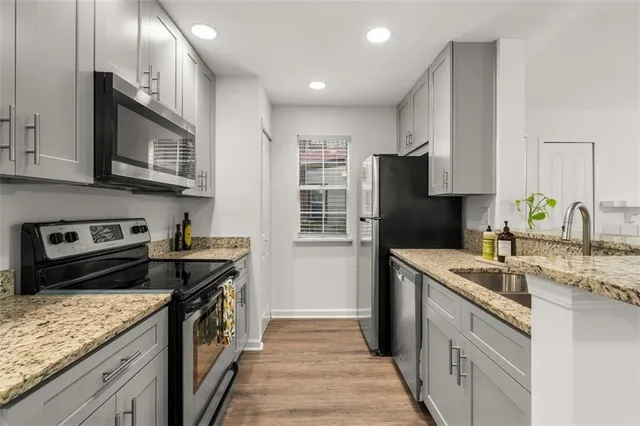a kitchen with stainless steel appliances granite countertop a stove sink and cabinets
