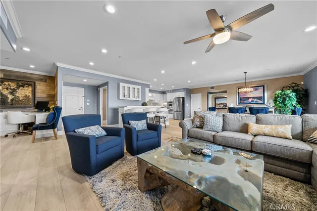 a living room with furniture kitchen view and a chandelier