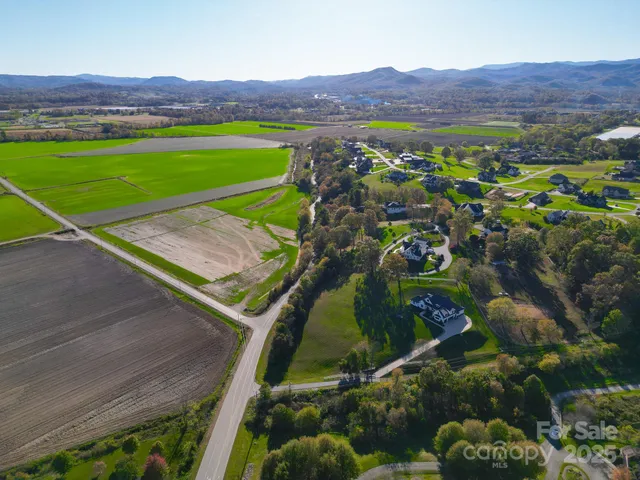 a view of a lush green field with a view of mountains and valleys