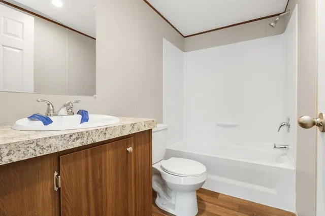 a bathroom with a granite countertop sink a toilet and shower