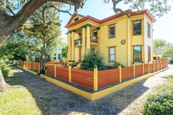 a view of a house with a small yard and wooden fence