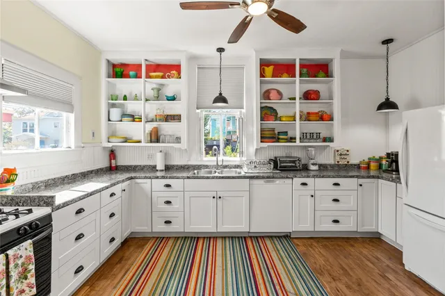 a large kitchen with granite countertop a sink stainless steel appliances and cabinets