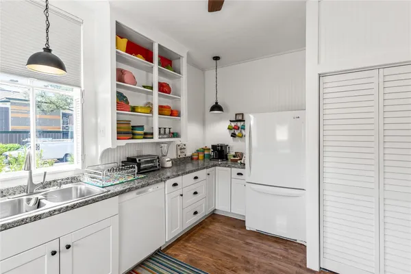 a kitchen with granite countertop a sink and a refrigerator