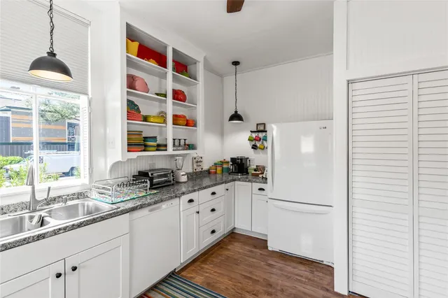 a kitchen with granite countertop a sink and a refrigerator