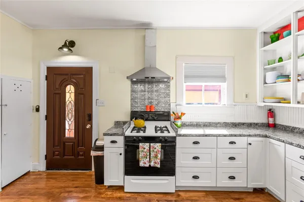 a kitchen with stainless steel appliances granite countertop a stove cabinets and wooden floor