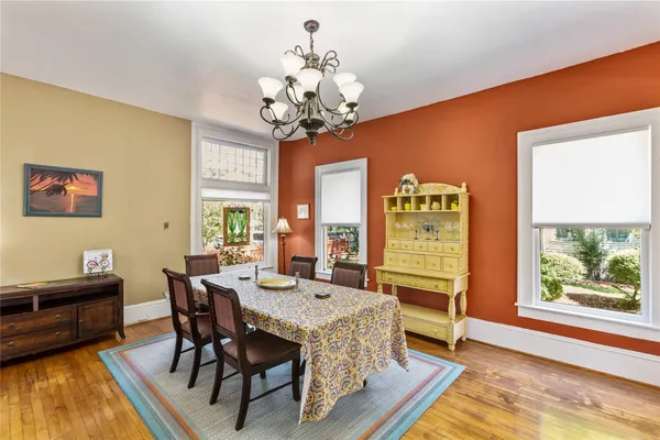 a view of a dining room with furniture a chandelier and wooden floor