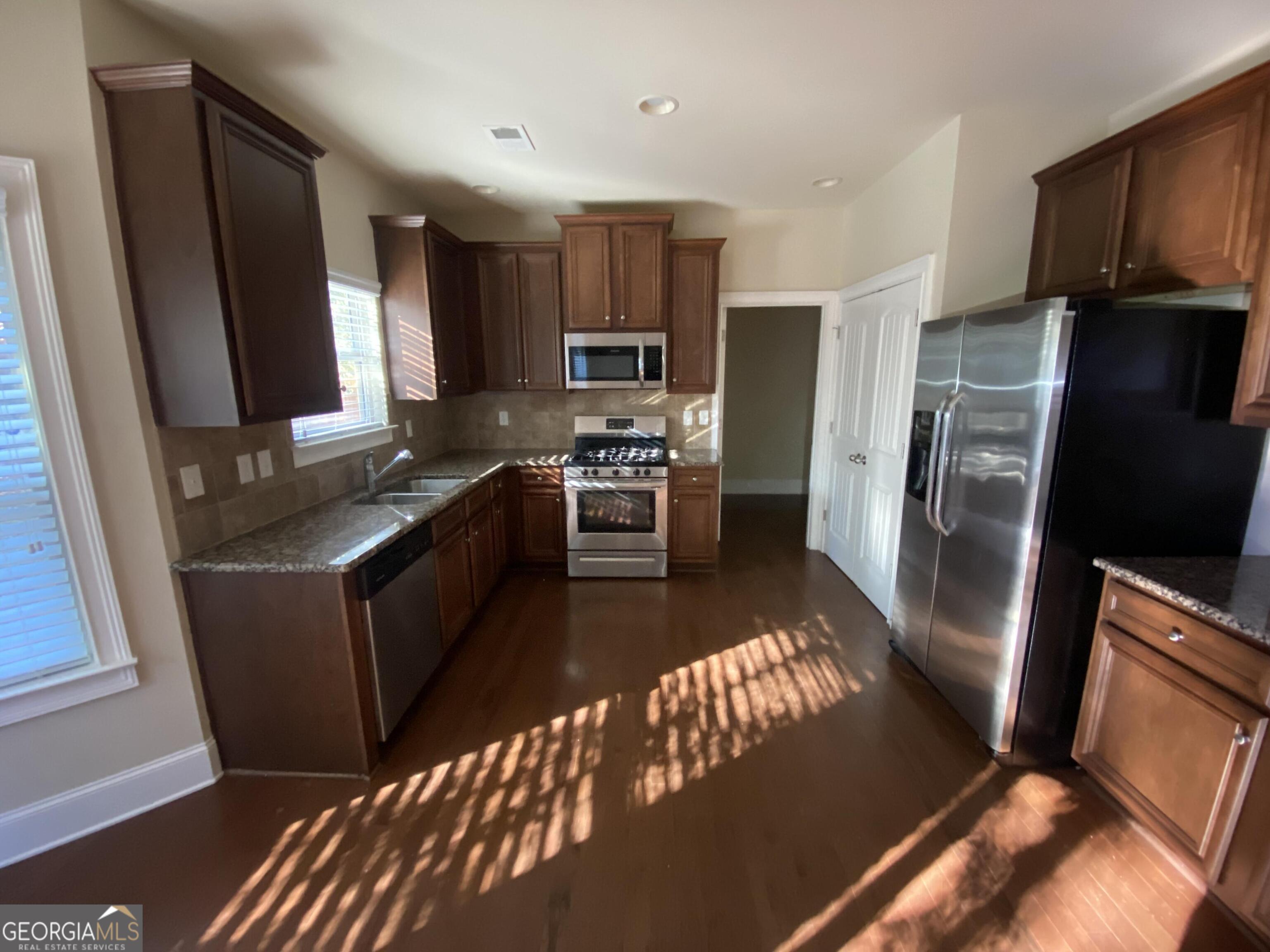 5441 Stirrup Way Powder Springs, GA 30127 - Photo 2 of 17 a kitchen with stainless steel appliances granite countertop a refrigerator stove and sink