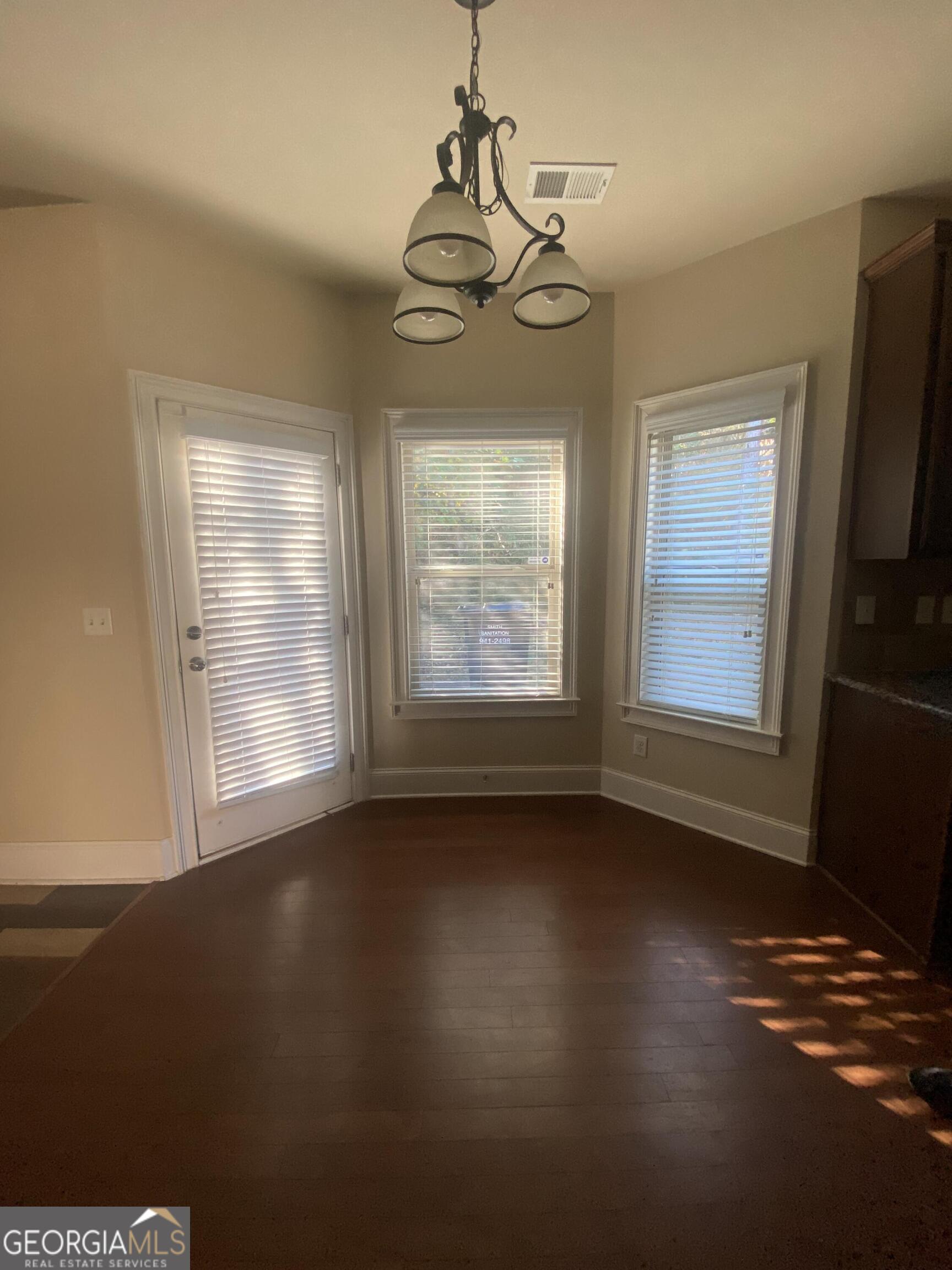 5441 Stirrup Way Powder Springs, GA 30127 - Photo 8 of 17 a view of an empty room with wooden floor and a window