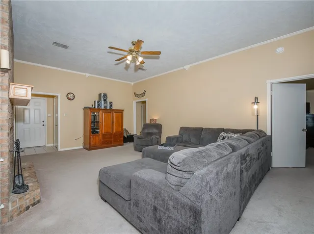 a living room with furniture and a ceiling fan