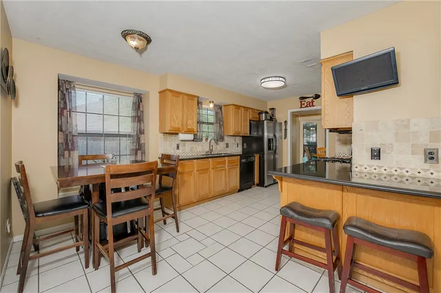 a kitchen with a table chairs refrigerator and microwave