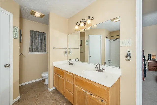 a spacious bathroom with a double vanity sink a large mirror and a shower