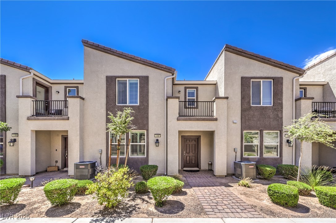 View of front of home with a balcony and stucco siding