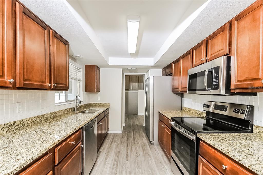 2902 Ripplewood Drive Seffner, FL 33584 - Photo 6 of 18 a kitchen with stainless steel appliances granite countertop a stove a sink and a microwave