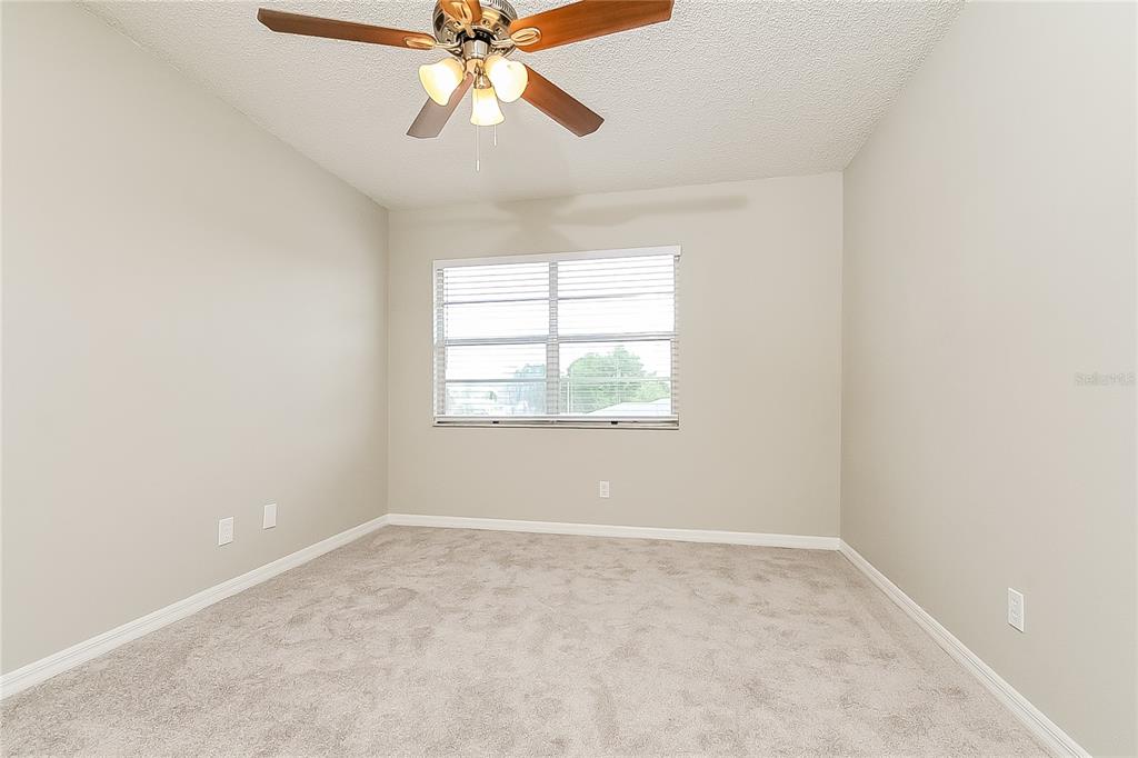 2902 Ripplewood Drive Seffner, FL 33584 - Photo 10 of 18 an empty room with windows and chandelier fan