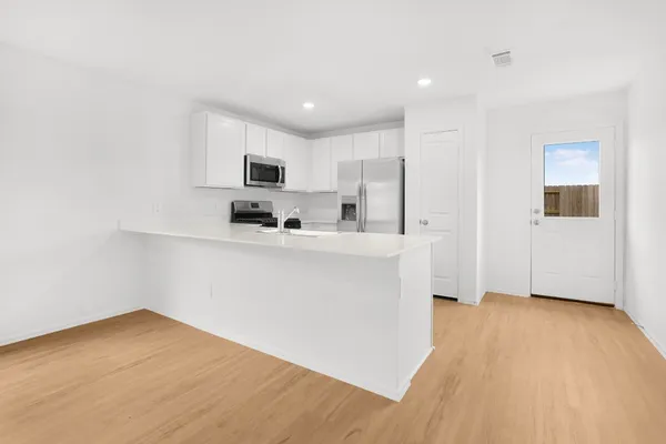 a kitchen with stainless steel appliances a sink a stove a microwave and cabinets