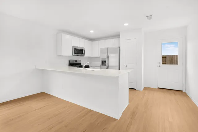 a kitchen with stainless steel appliances a sink a stove a microwave and cabinets