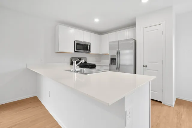 a kitchen with stainless steel appliances a refrigerator sink and microwave