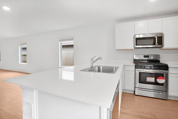 a kitchen with stainless steel appliances granite countertop a stove a microwave and a refrigerator