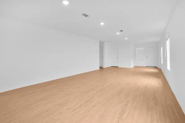 a view of empty room with wooden floor