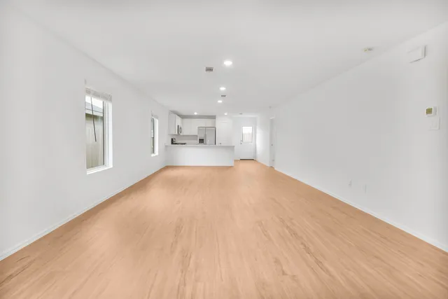 a view of empty room with wooden floor