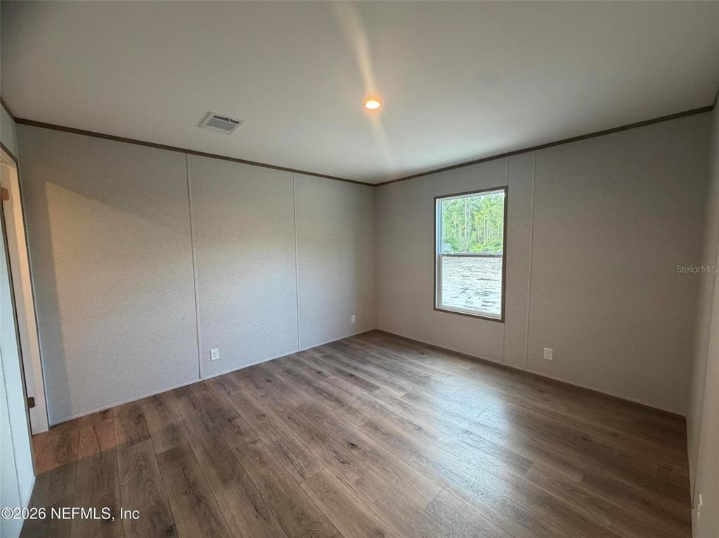 114 Nutmeg Trail Interlachen, FL 32148 - Photo 22 of 33 an empty room with wooden floor and windows