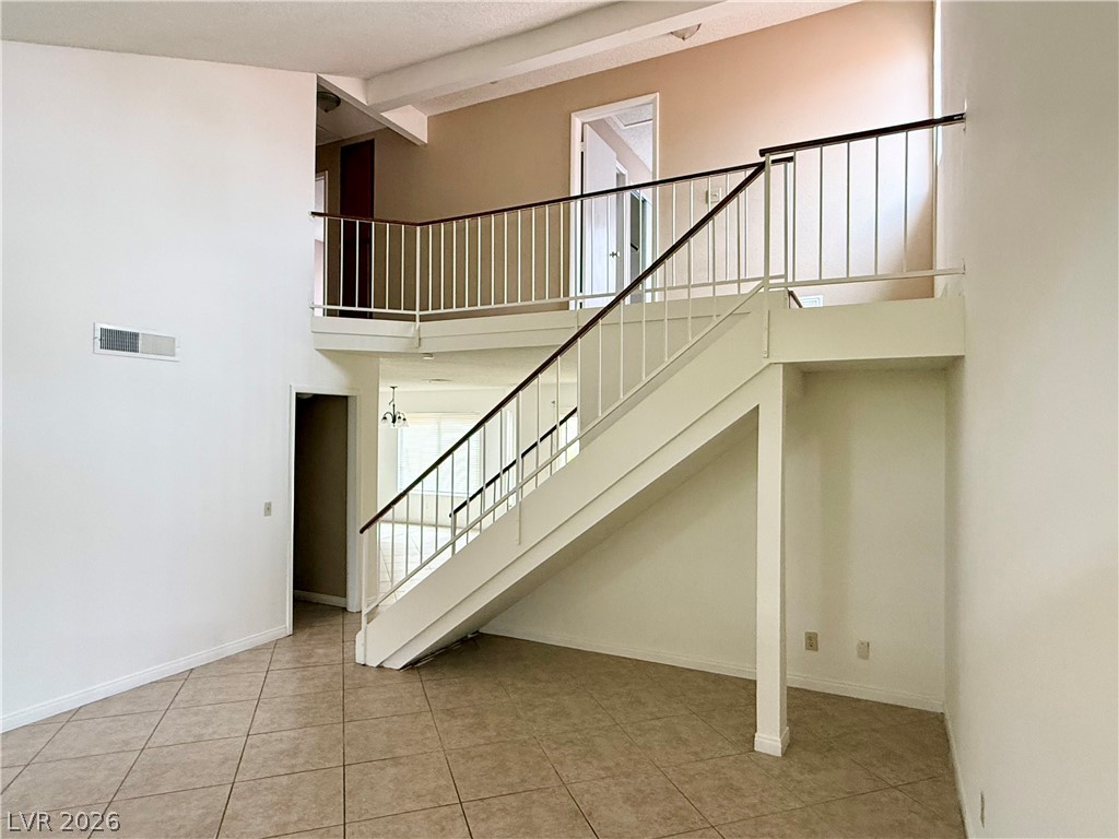 135 Primero Way Henderson, NV 89074 - Photo 3 of 15 A striking dual-level entry with a sleek staircase defines this spacious interior.