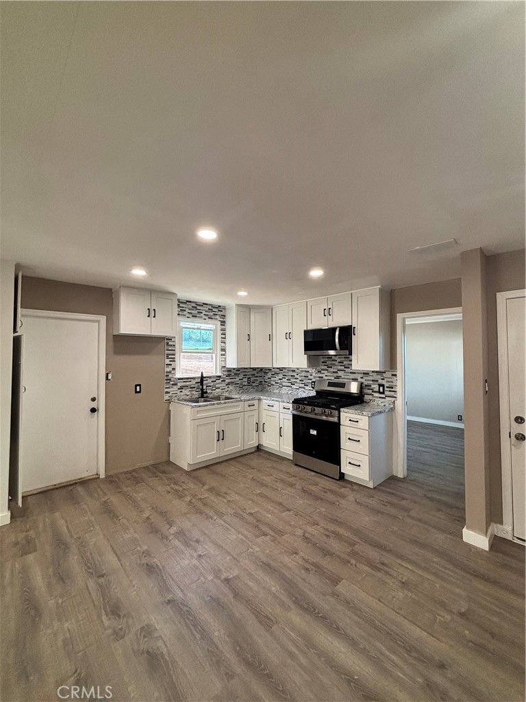 15360 Washington Street Riverside, CA 92506 - Photo 3 of 14 a kitchen with stainless steel appliances kitchen island granite countertop a stove and a refrigerator